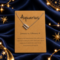 Aquarius zodiac necklace on a star-themed satin background