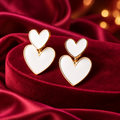 Cream Double Heart Fashion Stud Earrings on decorative coloured satin background