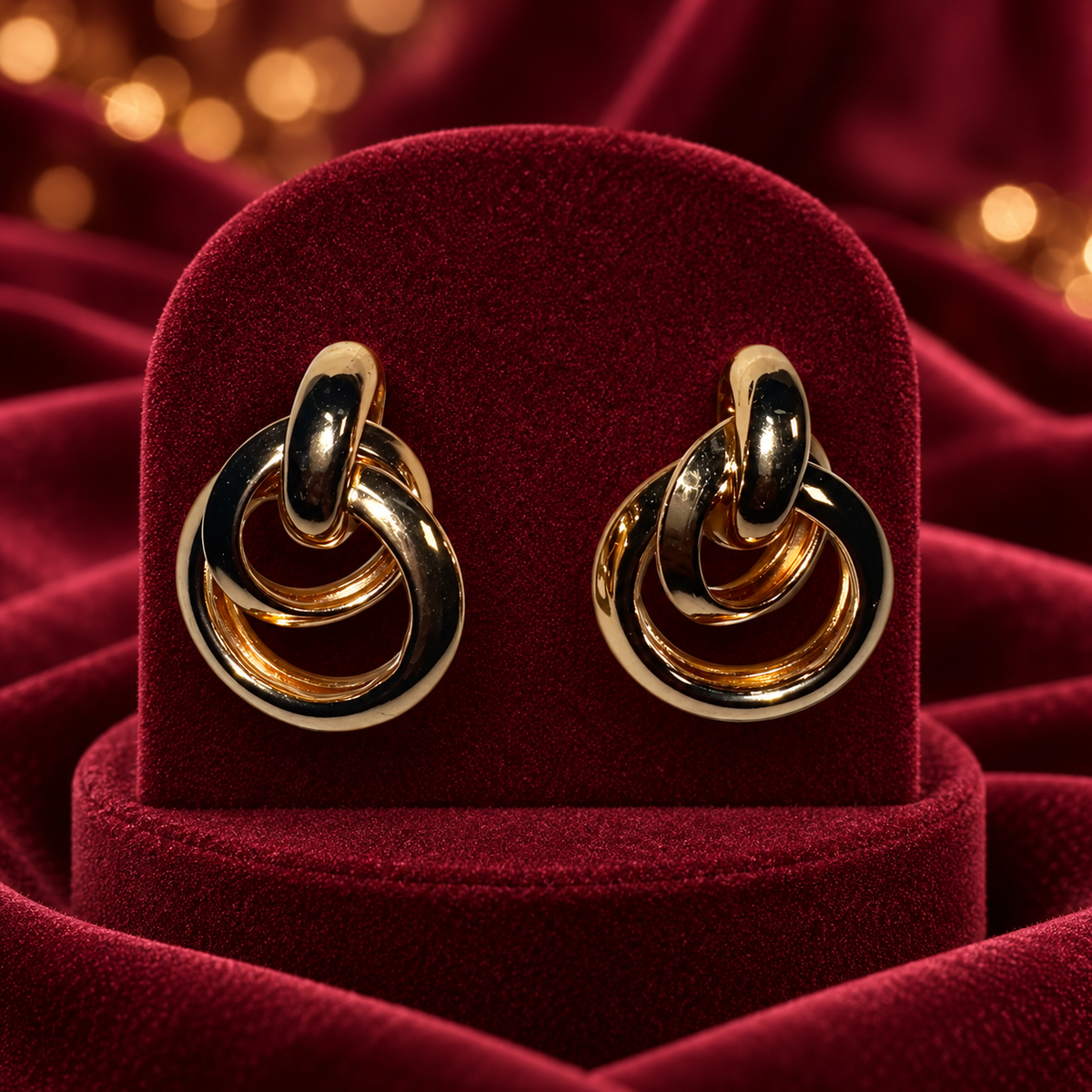 Gold-Tone Interlocking Multi-Ring Statement Earrings on burgundy satin and velvet