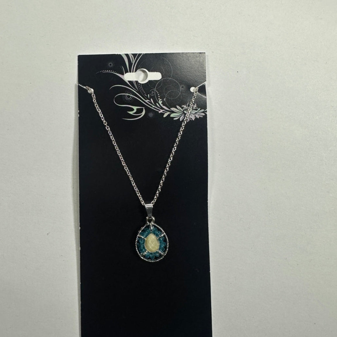 Necklace featuring blue teardrop halo pendant