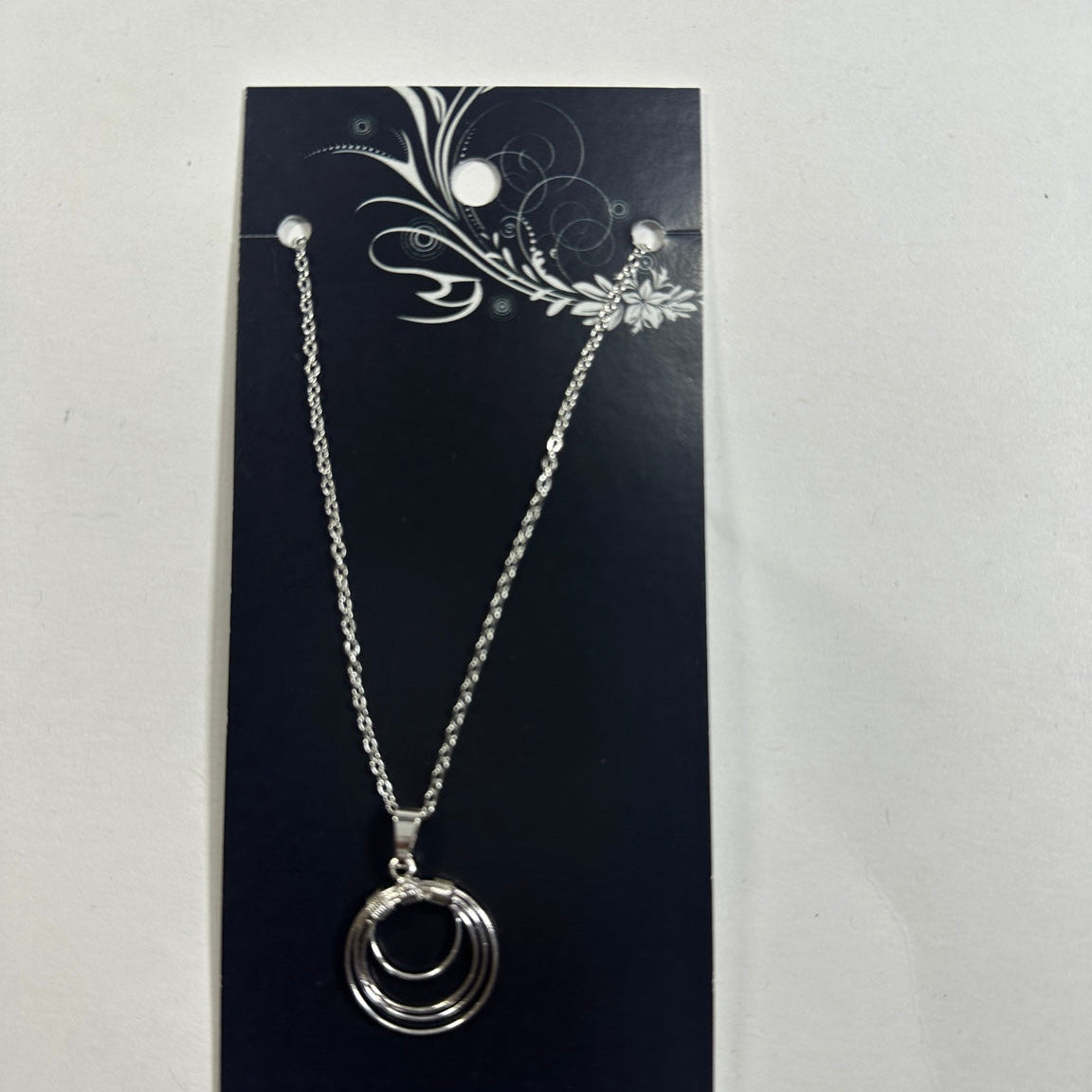 Necklace featuring silver concentric circle pendant