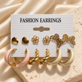 Heart flower butterfly and pastel hoop earrings six-pair set on cream satin background