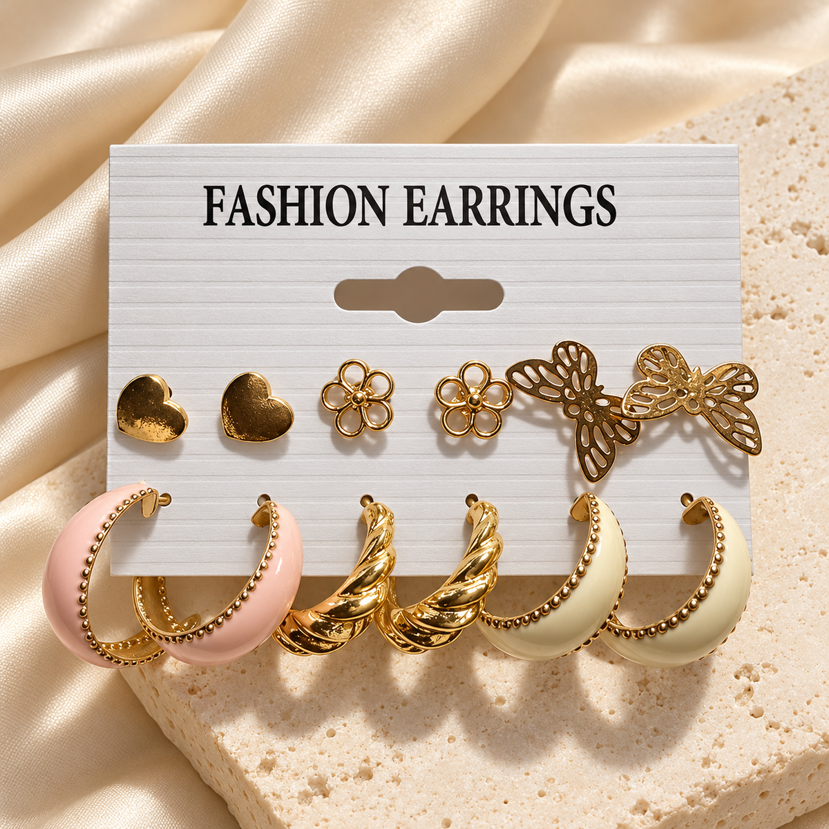 Heart flower butterfly and pastel hoop earrings six-pair set on cream satin background
